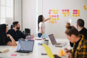 Photo d'une réunion en équipe avec présentation au tableau de post-it