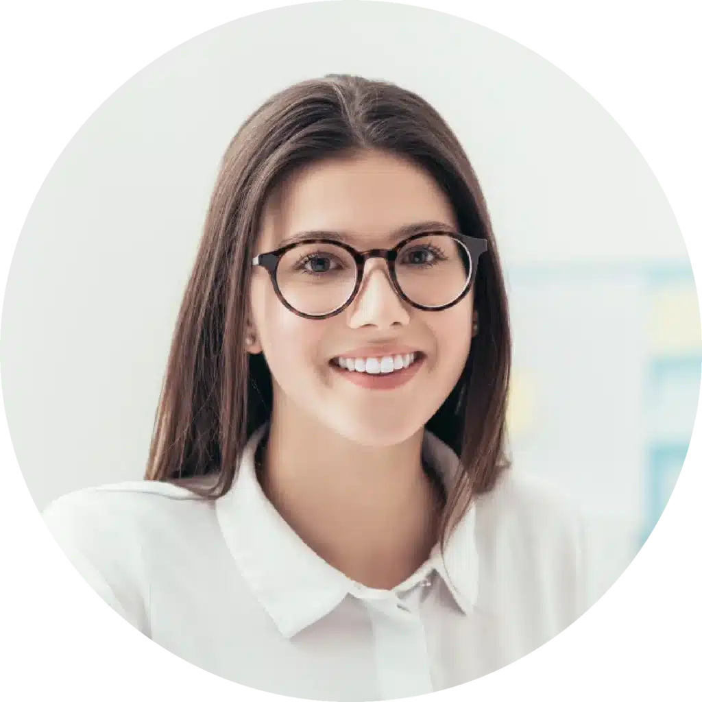 Portrait d'une femme souriante avec lunettes et chemise blanche.